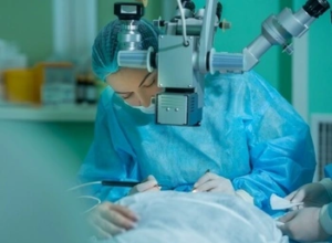 A patient resting their chin on a modern OCT imaging device for a retinal scan A patient resting their chin on a modern OCT imaging device for a retinal scan